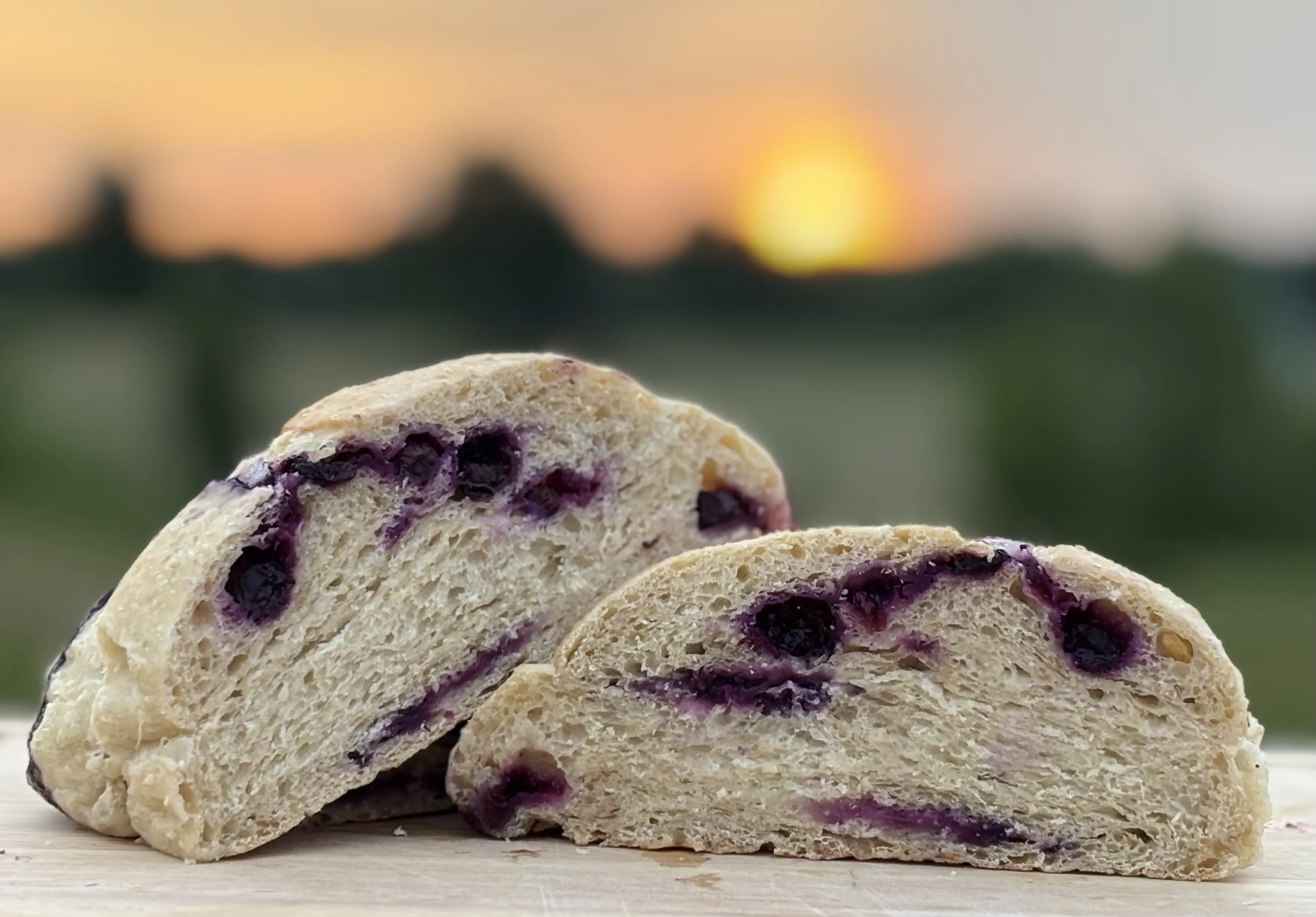Blueberry lemon sourdough cut in half with a sunrise in the background